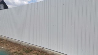 Белый забор из профнастила на фундаменте